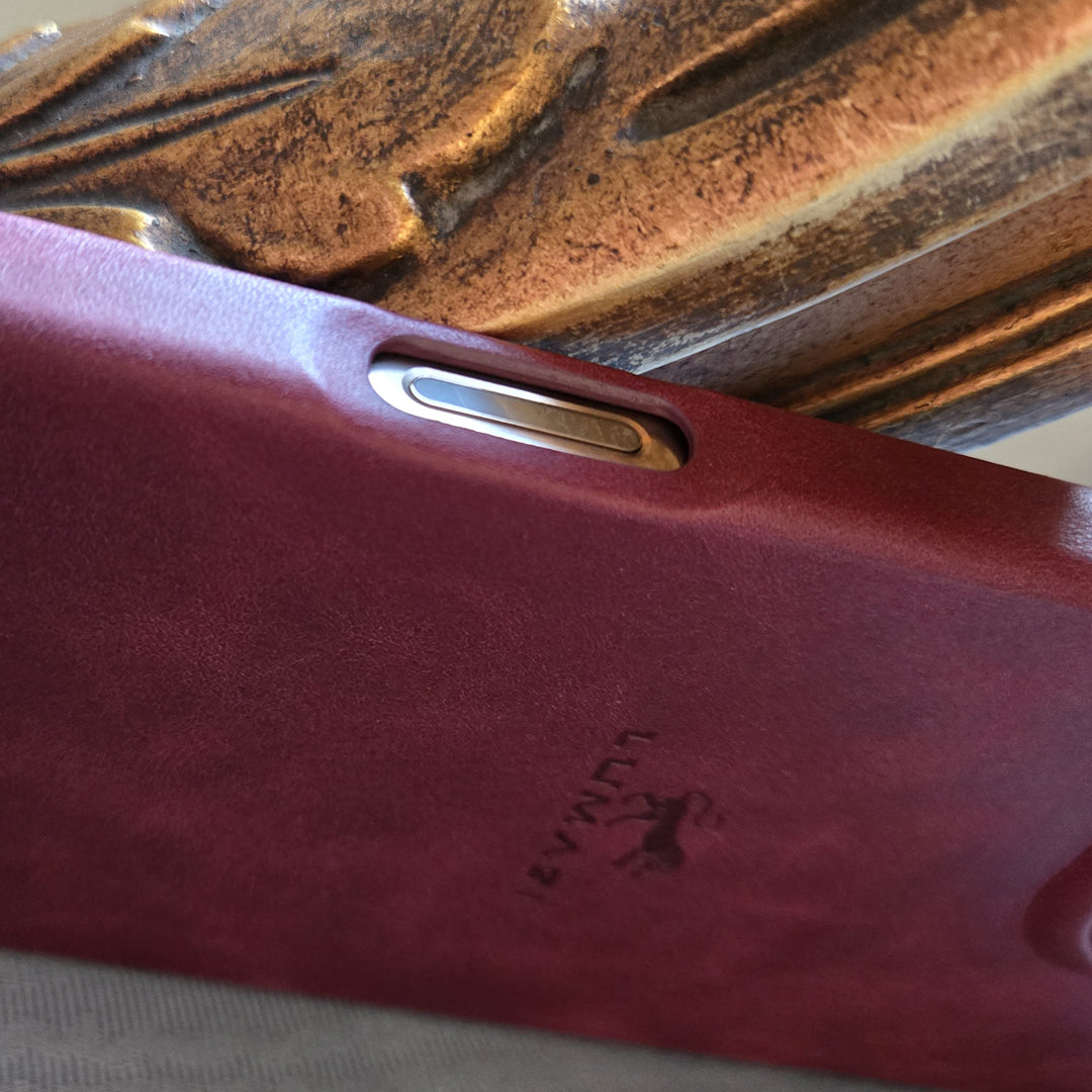 Pomegranate red camera control button on the handmade, full-grain leather MagSafe iPhone 16 Pro Max case